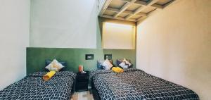 玛琅马朗玛多尔多姆旅舍的带两张床和镜子的客房
