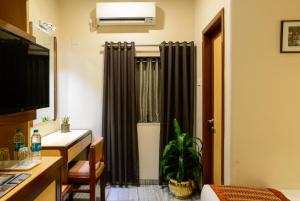 孟买Hotel Ameya的酒店客房,设有床和带窗帘的窗户。