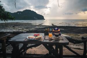 皮皮岛皮皮岛余晖湾度假酒店的海滩上的野餐桌,提供食物和饮料