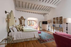 基安蒂盖奥勒Castello Di Meleto的卧室配有一张床和一张桌子及椅子