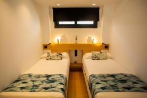塞维利亚塞维利亚圣约斯塔旅舍 - 仅限成人入住 的小型客房设有两张单人床和窗户。