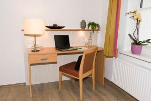 LenzingFerienwohnungen - Boarding Wohnungen Sonnenhof的一张桌子,一张笔记本电脑和一把椅子放在房间里