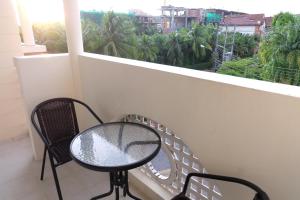 卡塔海滩Phuket Racha Kata Homestay的阳台配有桌椅和窗户