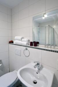 特里尔Ricks City Hotel的白色的浴室设有水槽和镜子