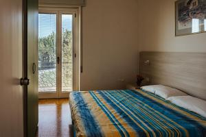 马内尔巴Camping Zocco的一间卧室设有一张床和一个滑动玻璃门