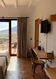 埃斯库约斯帕莱索农庄酒店的一间卧室配有一张床、一张书桌和一个窗户。