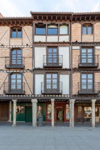 阿尔卡拉德荷那利斯Apartamentos Ejemplares的一座古老的砖砌建筑,设有窗户和阳台