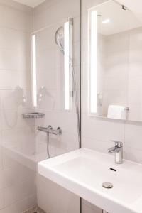 瓦利塞伦B&B HOTEL Zürich Wallisellen的白色的浴室设有水槽和淋浴。
