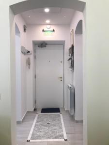 布加勒斯特Victoria Luxury Apartment 11的走廊设有白色门,铺有瓷砖地板