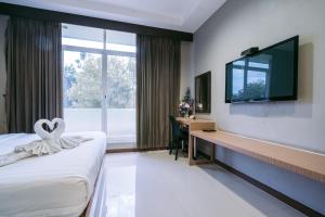 武里南金塔娜度假酒店的酒店客房配有一张床、一张书桌和一台电视。