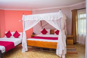 奈瓦沙伯奇奈瓦沙度假村的一间卧室配有两张床和一张天蓬床。