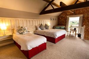 达宁顿堡多宁顿公园农舍酒店的一间卧室设有两张床和砖墙