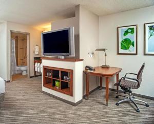 布鲁艾施Hyatt Place Cincinnati Blue Ash的酒店客房配有电视、书桌和椅子。