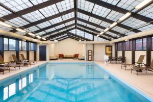 绍姆堡芝加哥夏姆堡凯悦嘉轩酒店的一个带玻璃天花板和桌椅的室内游泳池