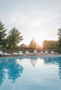 蒙科坦特Terres de France - Natura Resort Pescalis的游泳池配有白色躺椅和太阳