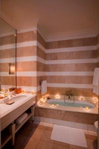 德班牡蛎盒子酒店的带浴缸、两个水槽和灯的浴室。