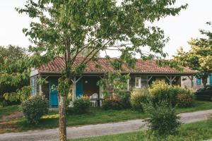 蒙科坦特Terres de France - Natura Resort Pescalis的前面有一棵树的房子