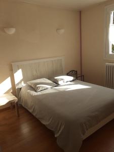 Isle-et-Bardaisle rond gardien的卧室设有一张白色大床和一扇窗户。