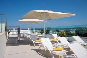 帕尔马海滩Hotel Seasun Aniram的屋顶上一组白色椅子和一把雨伞