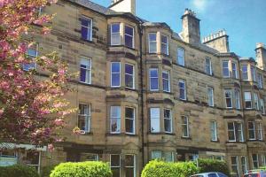 爱丁堡Woodburn Terrace, Morningside, Edinburgh的一座带窗户和树的大型砖砌建筑