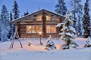 鲁卡VILLA KELO的雪地中的小木屋,有圣诞树