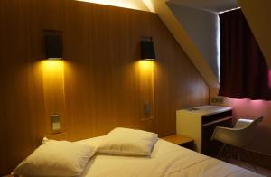奥特罗特Hôtel-Restaurant Mont Sainte-Odile的一间卧室配有一张带两个枕头的床和一张书桌