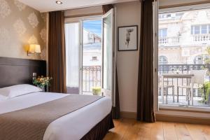 巴黎沃尔尼歌剧酒店的一间卧室设有一张床和一个大窗户