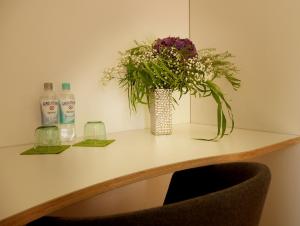 布吕尔Trafohaus am Kaiserbahnhof的桌子上一瓶装有瓶装水的花瓶