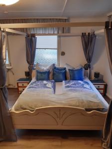 埃森Historisch übernachten Brinkerplatz 3的一间卧室配有一张带蓝色枕头的天蓬床