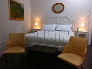 焦亚德尔科莱Dimora del Castellano的一间卧室配有一张带两把椅子和镜子的床
