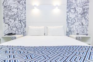 里约热内卢ibis Styles Rio de Janeiro Botafogo的卧室配有白色床和图案墙