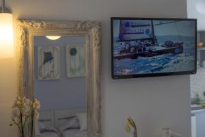帕罗奇亚Cyclades Studios的挂在墙上的镜子,上面有照片