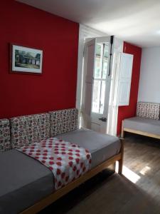 蒂格雷La Dolce Vita的一间卧室设有一张床和红色的墙壁