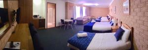 考拉Golden Chain Aalana Motor Inn的酒店客房带两张床,还有一间候机室