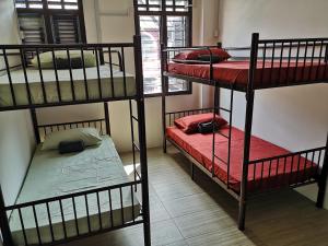 怡保Homey Hostel的客房设有三张双层床和一扇窗户。
