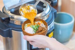 东广岛市东广岛船舶酒店的拿着一碗汤匙食物的人