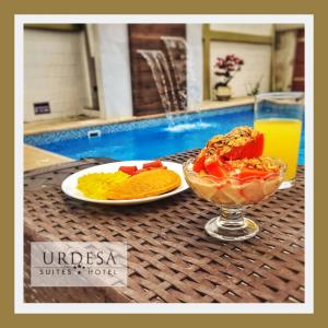 瓜亚基尔乌尔德萨套房酒店的一张桌子,上面放着两盘食物和一碗水果