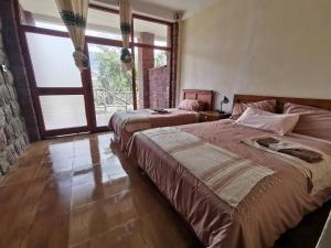 拉利贝拉Lalibela Apartments的一间卧室设有两张床和大窗户