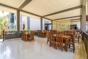 圣吉吉Grand Senggigi Hotel的用餐室配有木桌和椅子