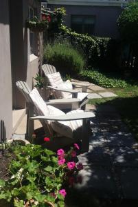 阿古拉斯吉夫特民宿的两把白色椅子坐在鲜花旁边的庭院