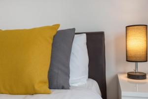 诺丁汉River Rooms Nottingham的一张带黄色枕头和灯的床
