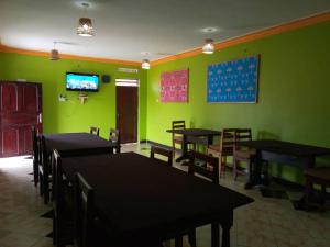 KapchorwaSipi Traveller's Lodge的用餐室设有桌椅和绿色的墙壁