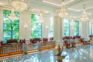 清迈The Empress Premier Chiang Mai - SHA Extra Plus的大堂设有吊灯和桌椅
