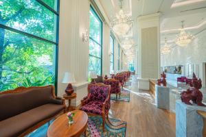 清迈The Empress Premier Chiang Mai - SHA Extra Plus的带沙发、椅子和窗户的客厅