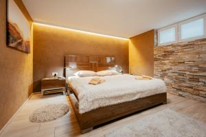 卢布尔雅那Apartments in Villa Olimp的一间卧室设有一张大床和砖墙