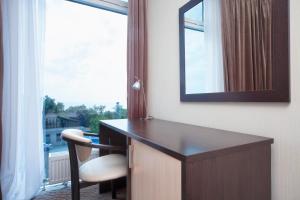 敖德萨奥特拉达黑海酒店的客房设有带镜子的书桌和窗户。