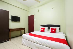 太平OYO 89549 Casavilla Hotel (city Centre) Taiping的一间卧室配有一张带红色枕头的大床