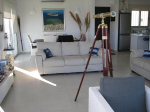 普罗塔拉斯三叉戟海滩公寓的客厅配有白色沙发和望远镜