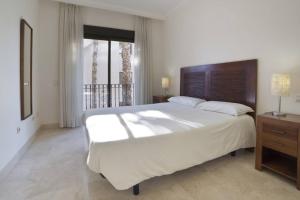 圣哈维耶尔La Roza de Roda Golf的一间带一张白色大床的卧室和一个阳台