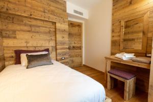 维托里奥·威尼托Relais Althea Azienda Agrituristica的一间卧室设有一张床和木墙